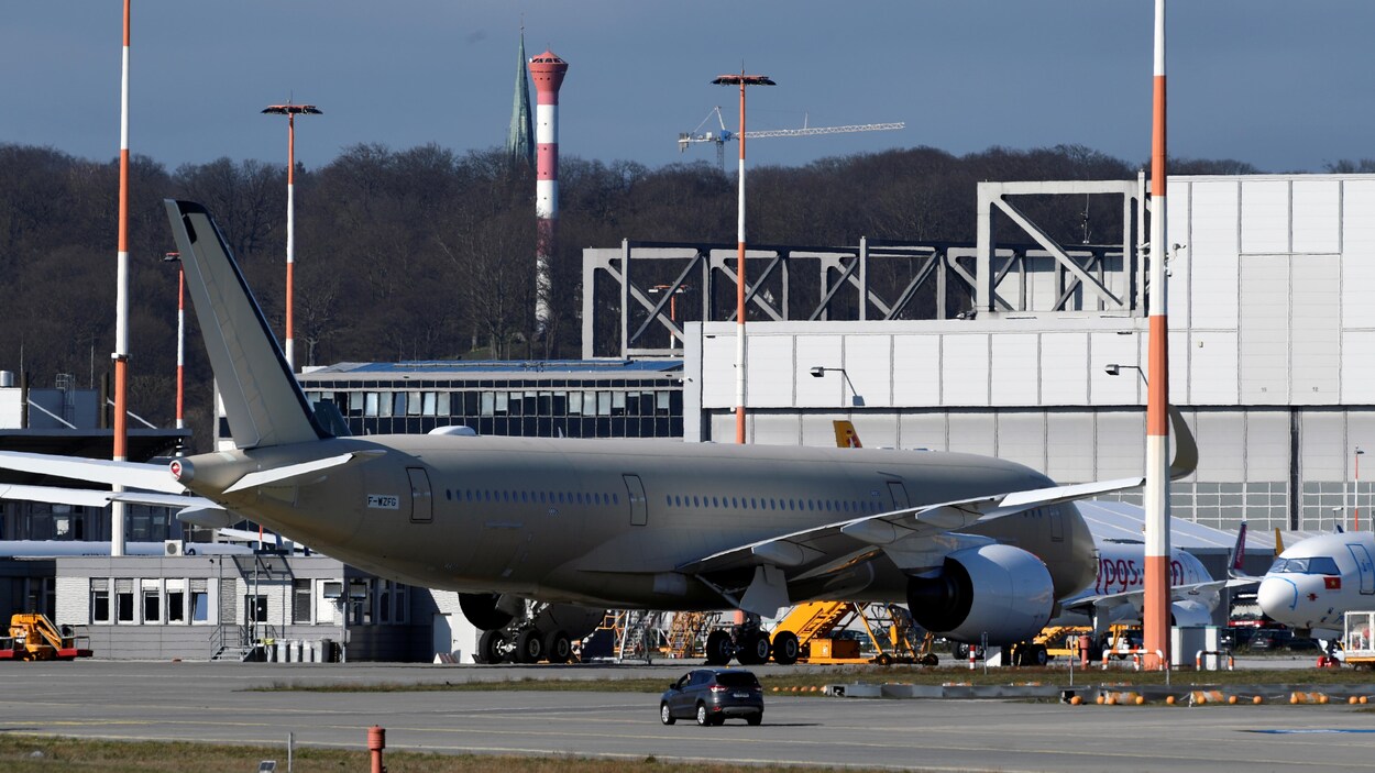 Un avion immobilisé à côté d'une usine.