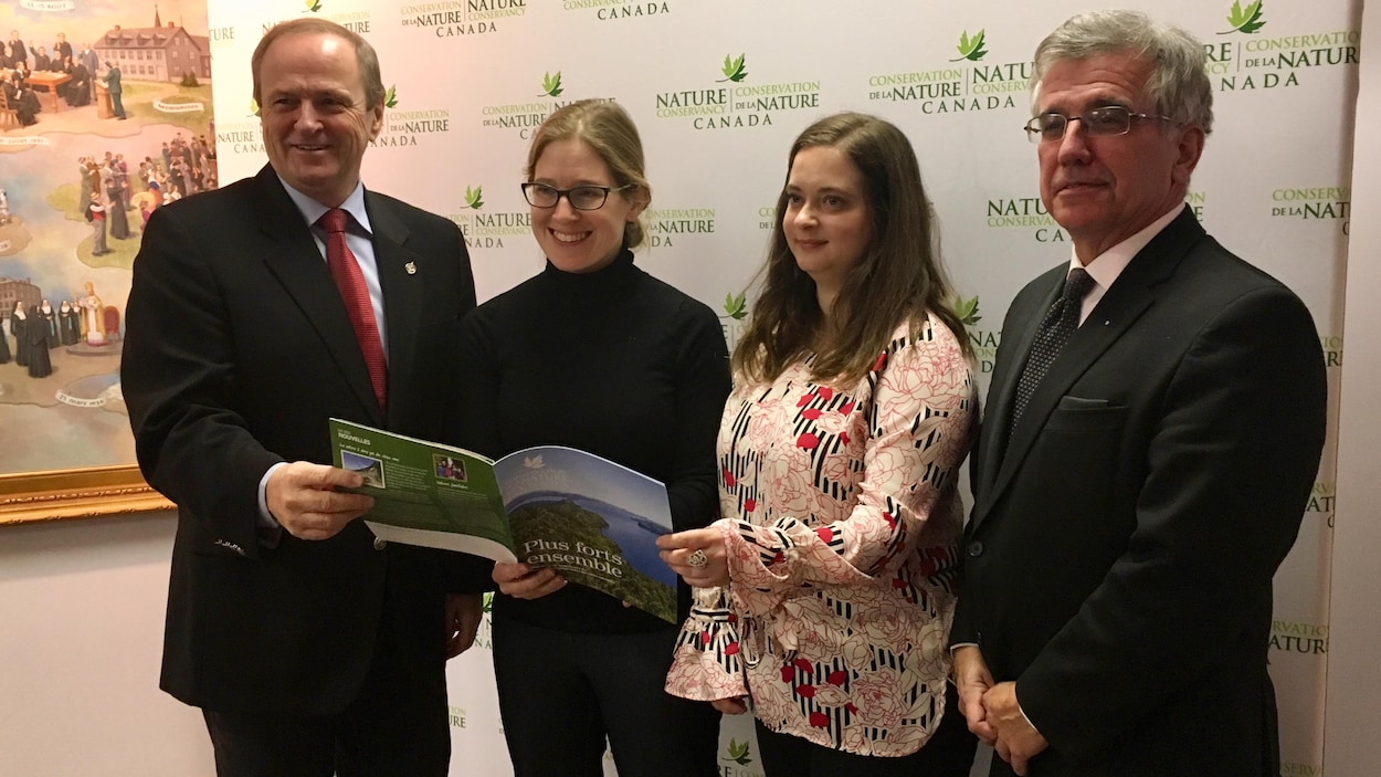 Le député fédéral Robert Morrissey et le ministre provincial de l'Environnement, Richard Brown, entourent Julie Vasseur de l'organisme Conservation de la nature Canada et Rachel Lapointe du Musée acadien de l'Île-du-Prince-Édouard.