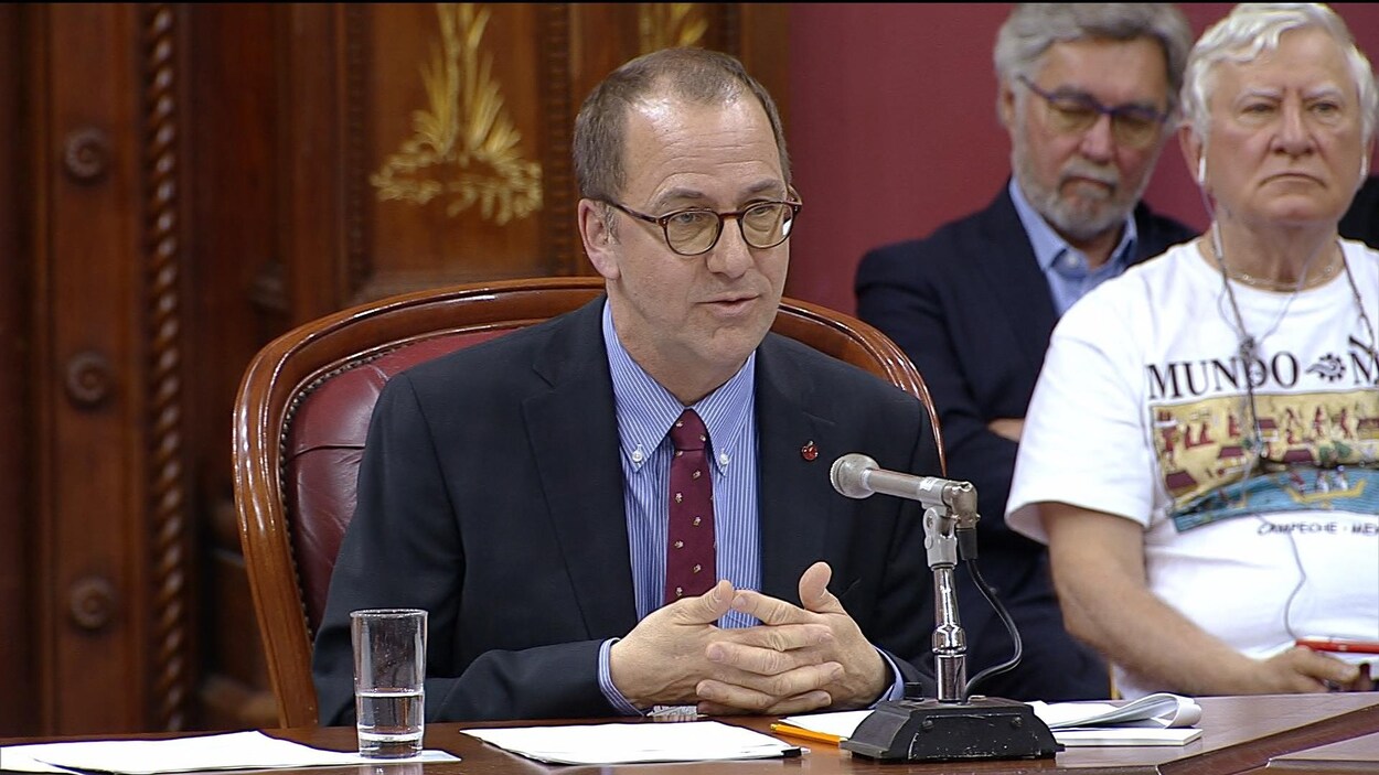 Alain Fortier, les mains jointes, s'adressant aux membres de la commission parlementaire des institutions.