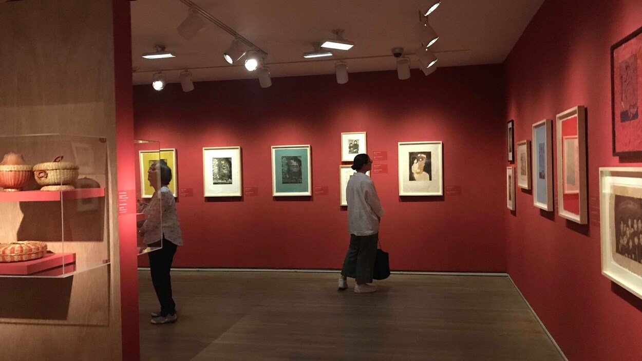 Des visiteurs observent les gravures d'Alanis Obomsawin.