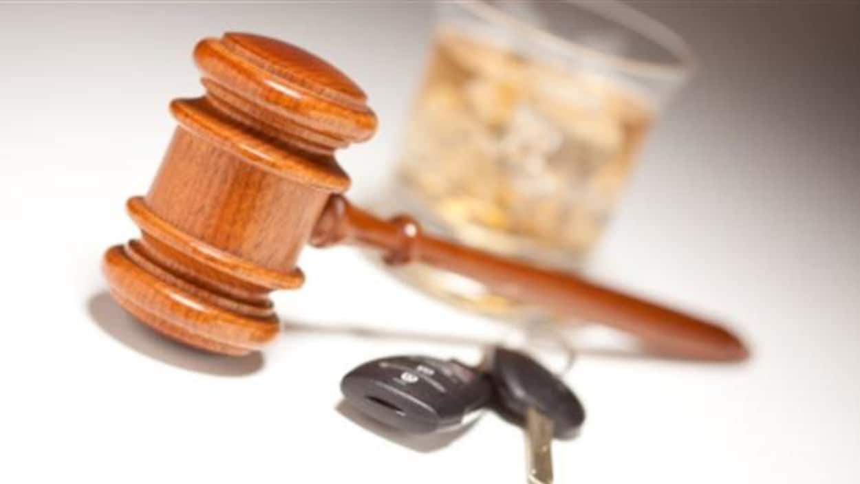 Un verre d'alcool avec des clés de voiture et un maillet