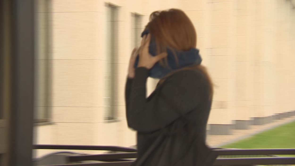 Photo floue d'une femme marchant en se couvrant le visage.