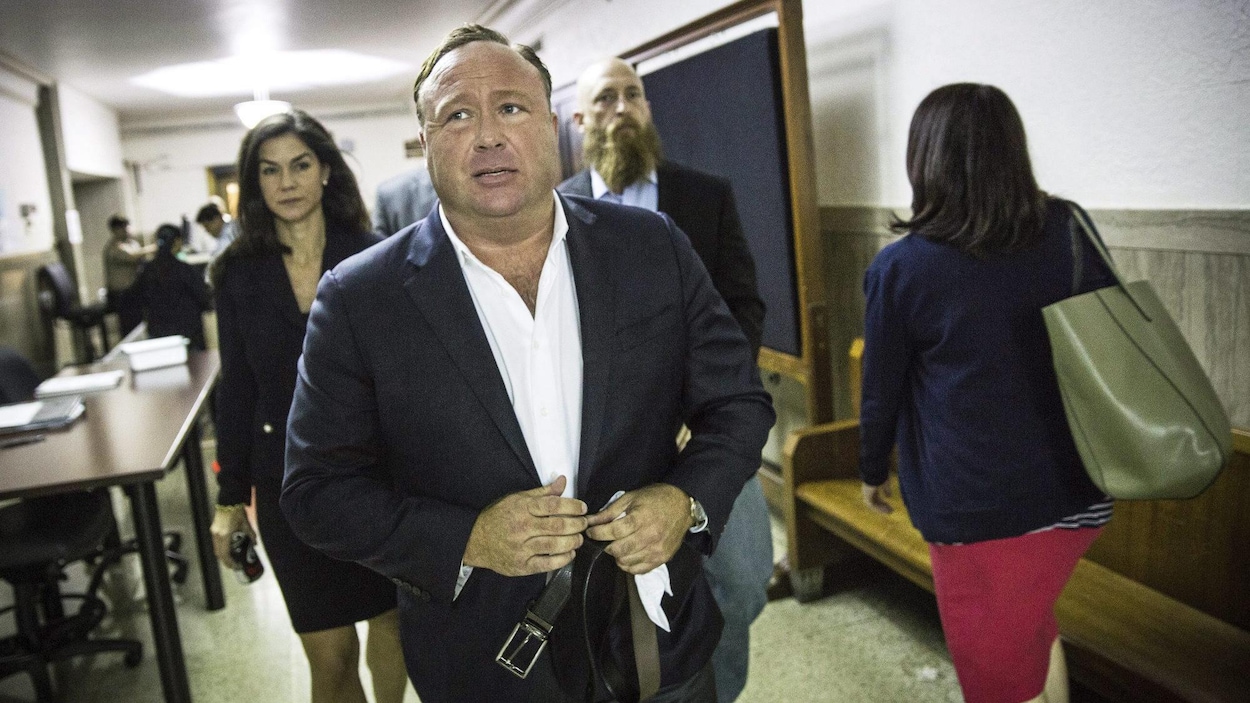 Alex Jones marche dans un corridor.