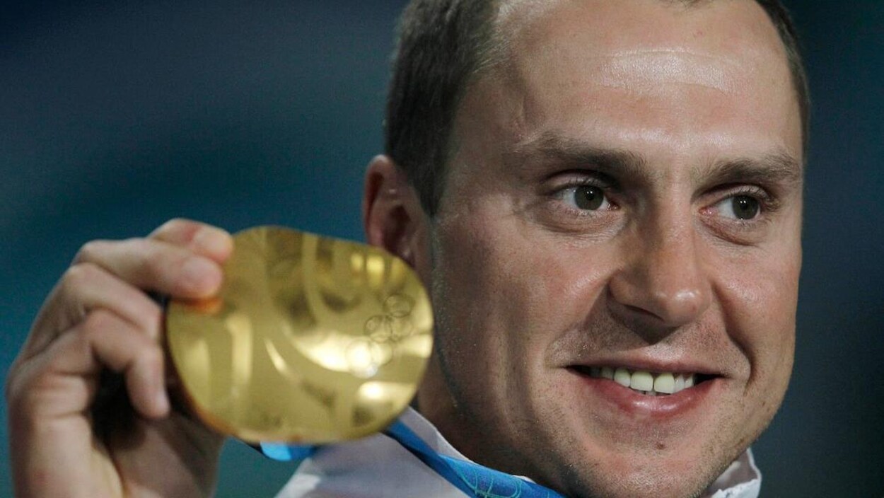 Un Olympien posant avec sa médaille d'or.