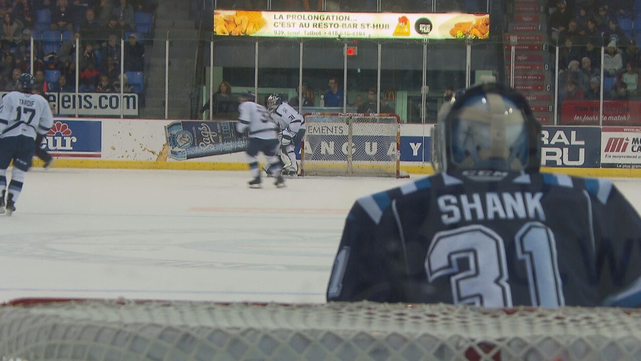 Le gardien de but Alexis Shank suit des yeux l'action qui se déroule à l'autre bout de la patinoire.