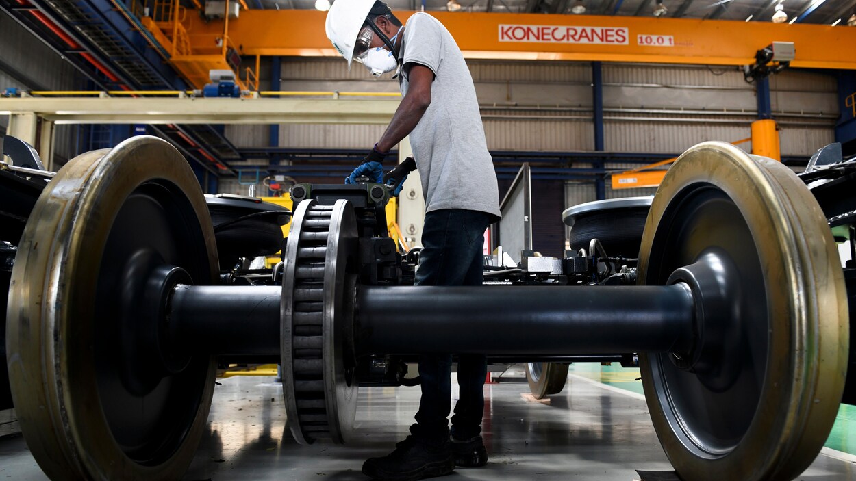Un homme travaille sur du matériel roulant dans une usine.