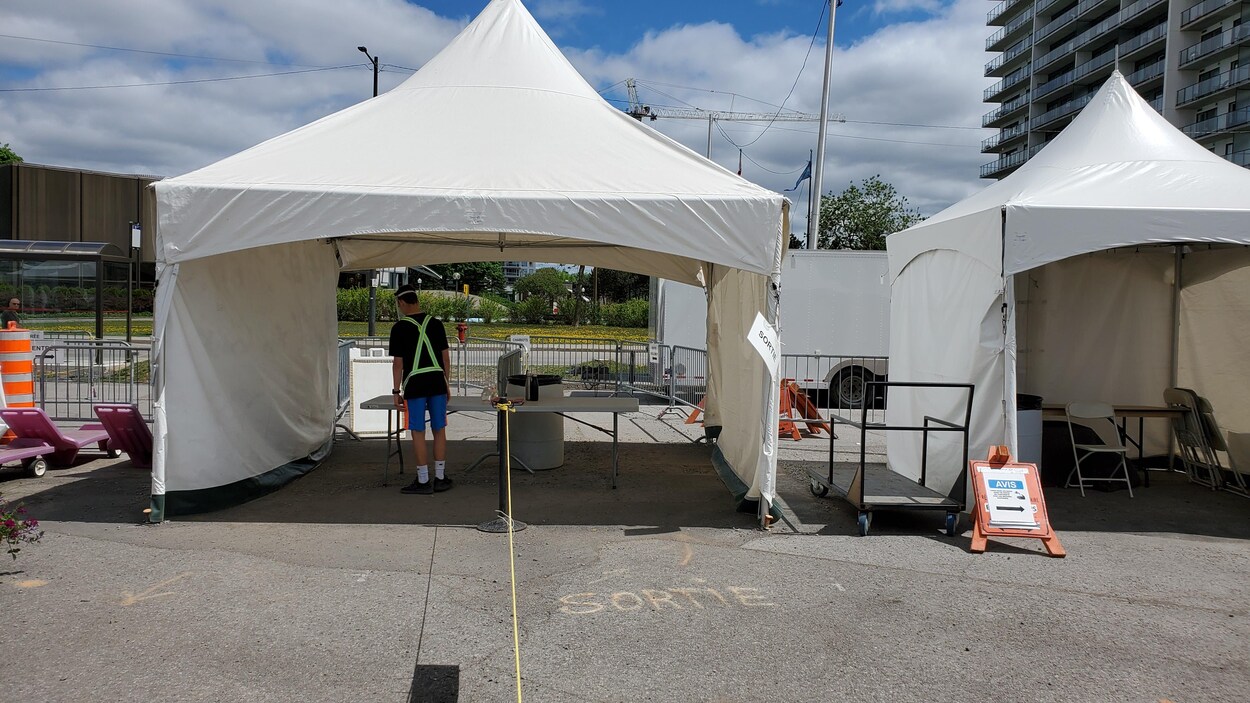 Un jeune préposé sous une tente au Marché public de Sainte-Foy