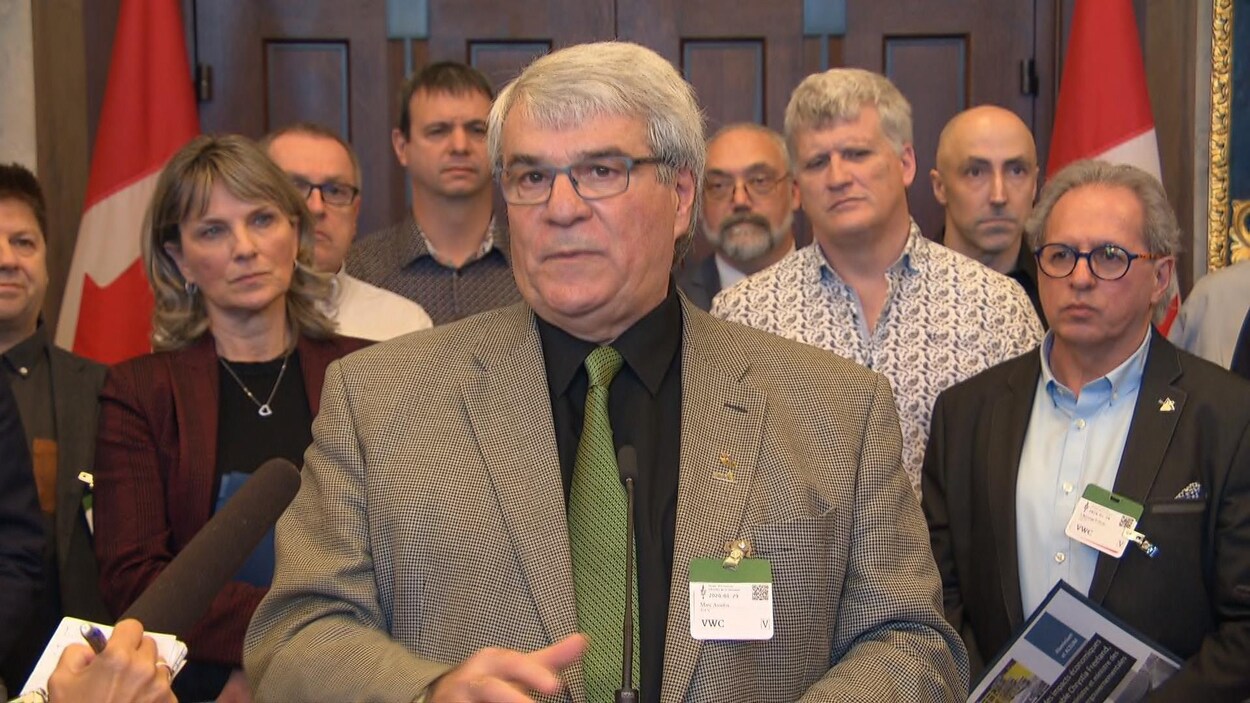 Un groupe de personnes debout dans les couloirs du parlement canadien.