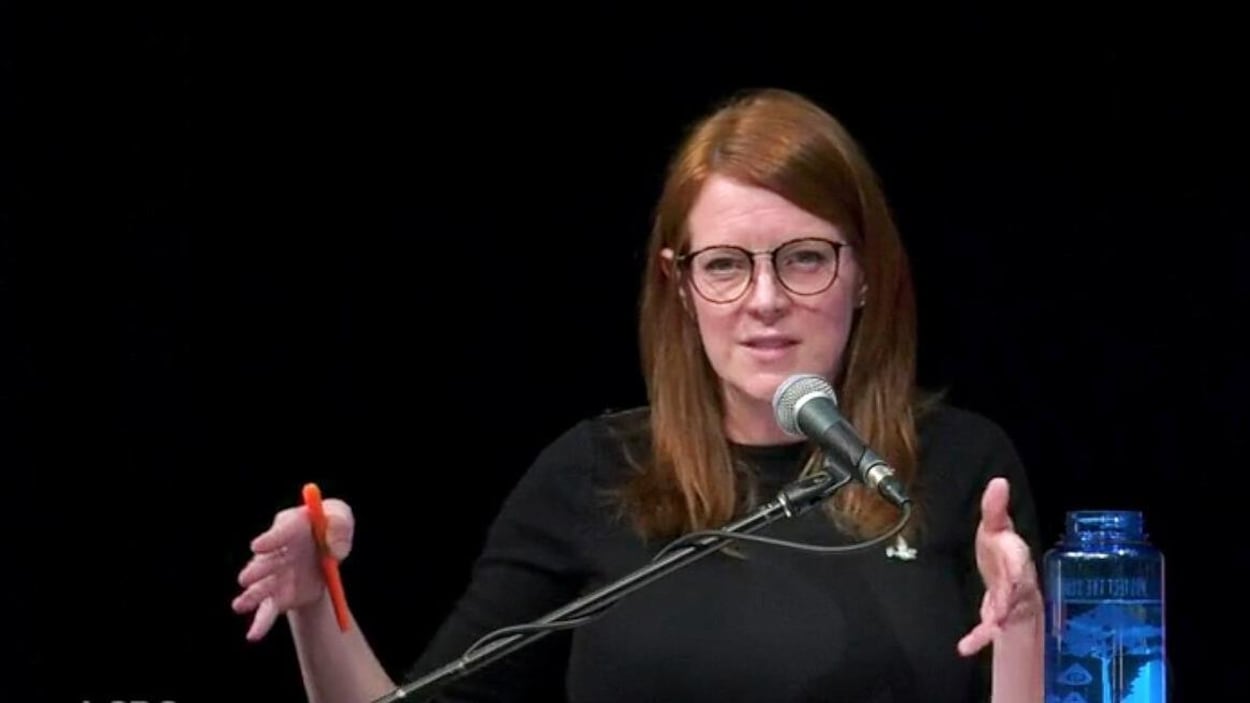 Amanda McDougall, parlant devant un micro.