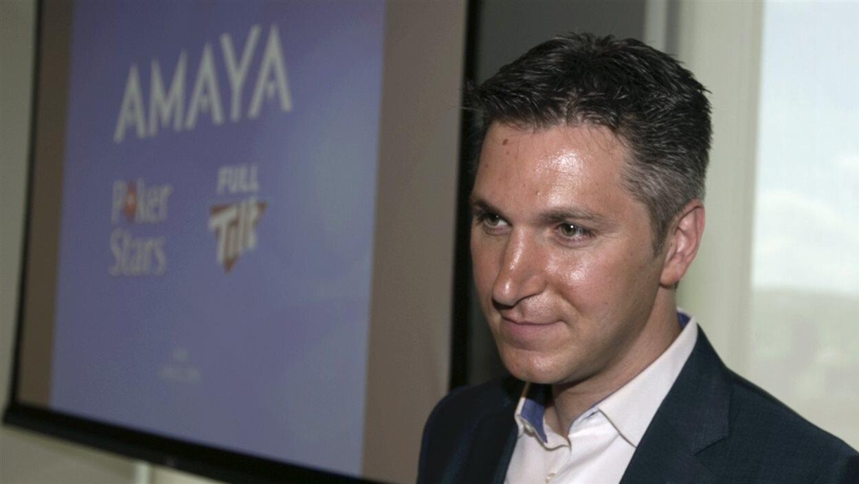 David Baazov photographié à côté d'un écran où l'on voit le nom Amaya.