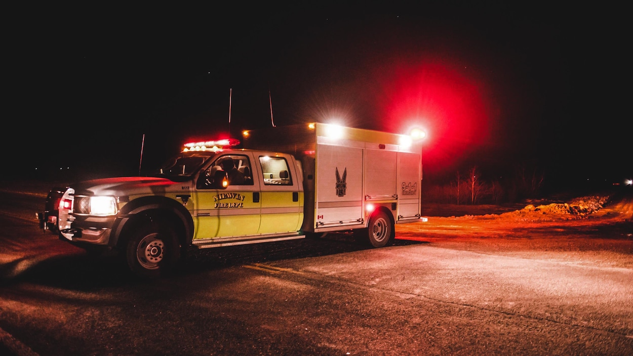 Un véhicule d'urgence la nuit qui bloque la route
