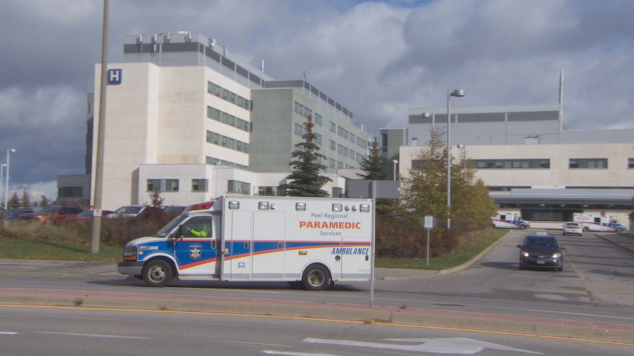Extérieurs de l'hôpital, avec en premier plan une ambulance.