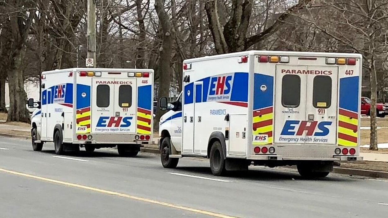 Deux ambulances circulant dans une rue.