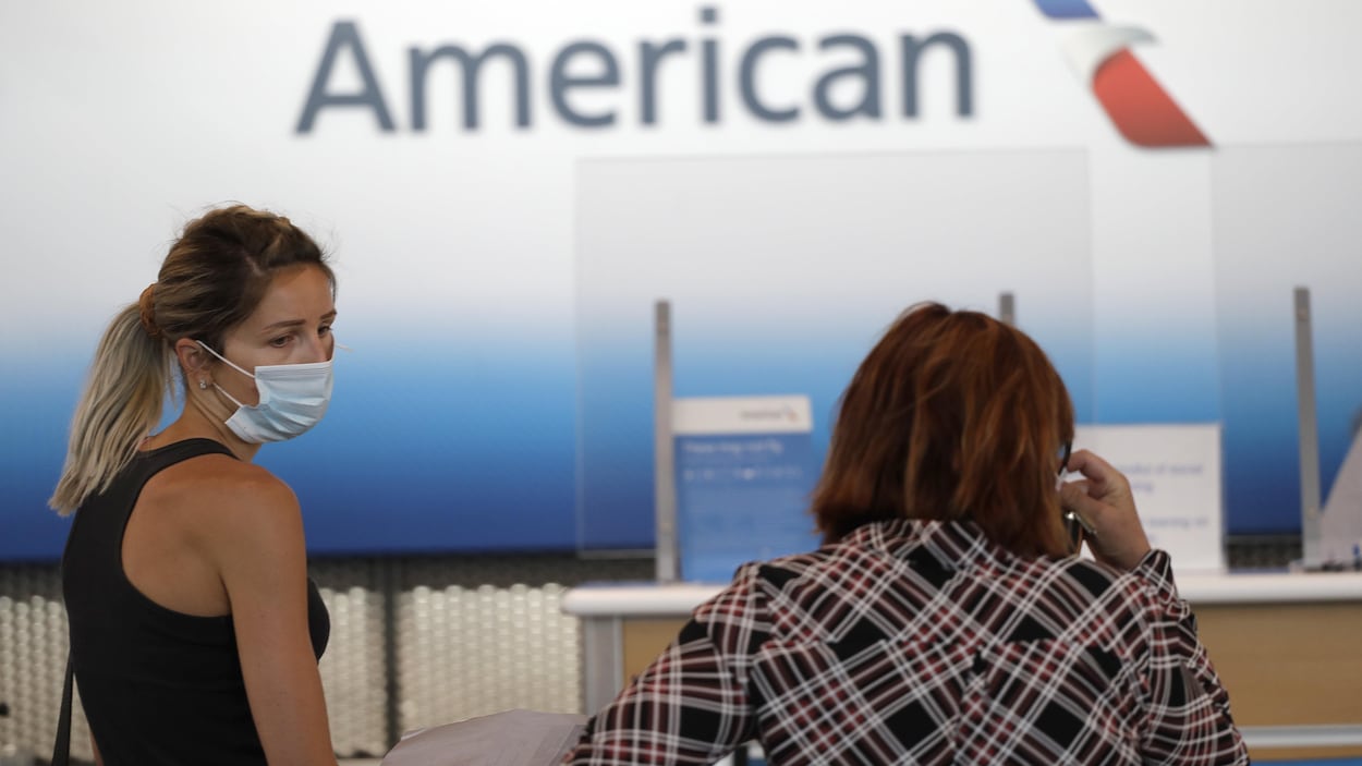 Deux femmes sont au guichet d'American Airlines,