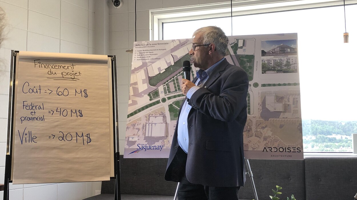Le conseiller municipal devant un tableau qui présente les chiffres.