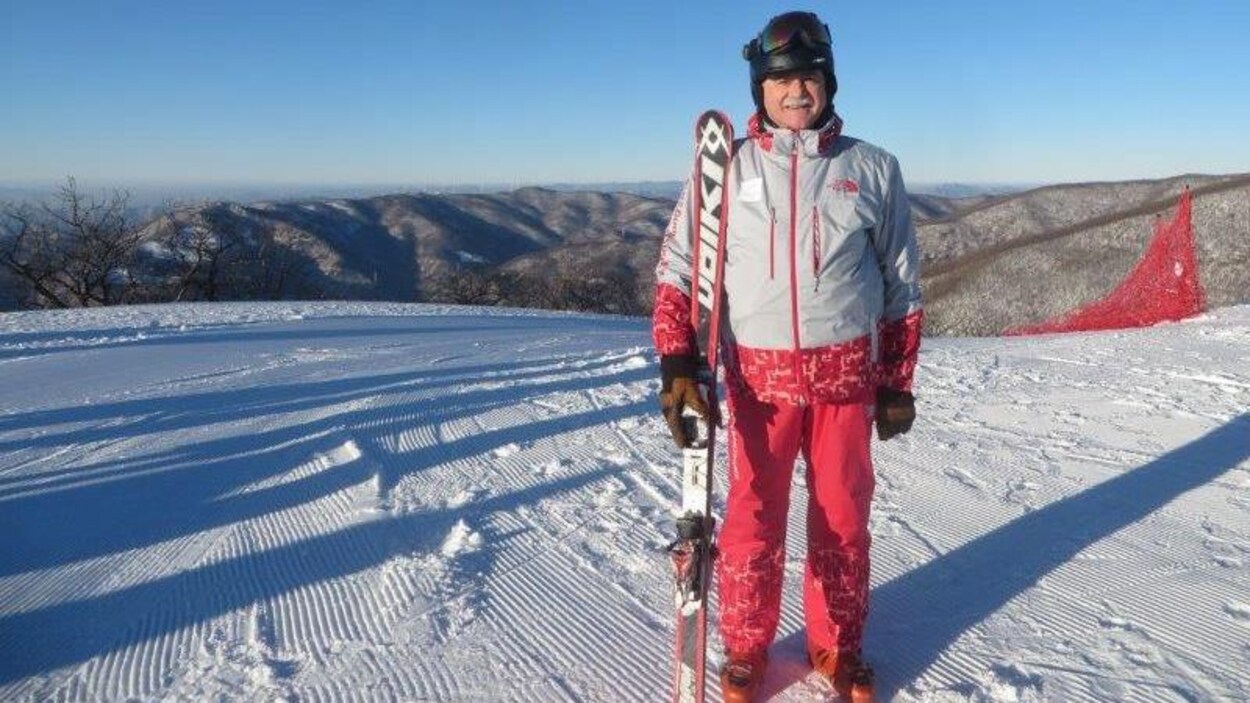 André Robert Labine tenant ses skis sur le haut d’une pente. André Robert Labine tenant ses skis sur le haut d’une pente.
