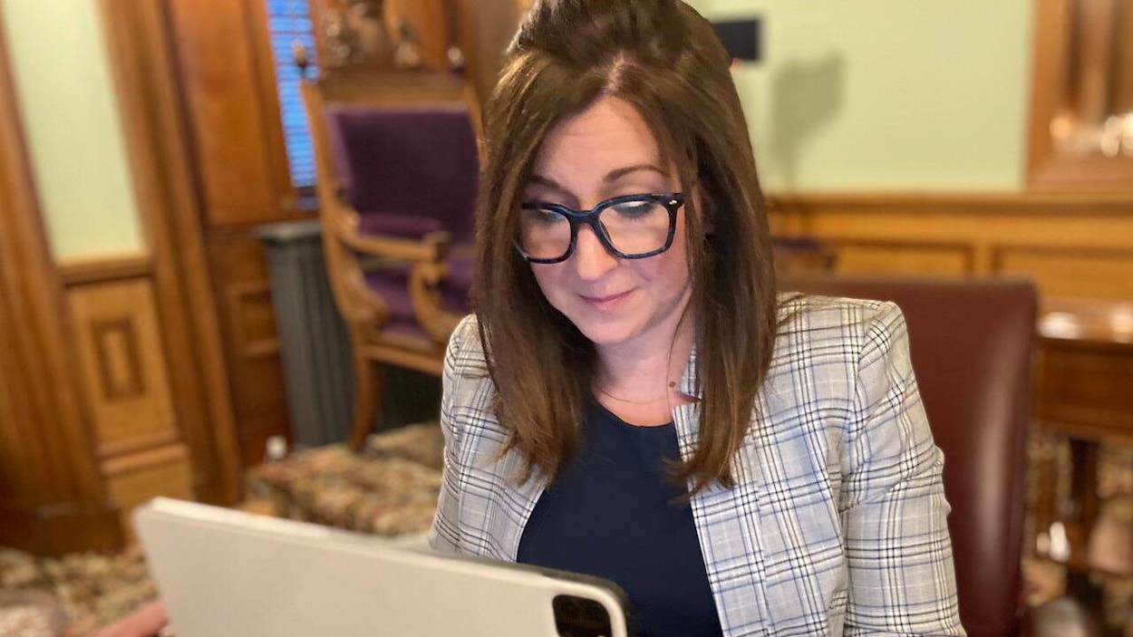 La députée Andrea Anderson-Mason assise, penchée sur son ordinateur portable.
