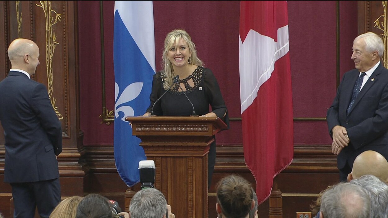 Une femme sourie à la salle.