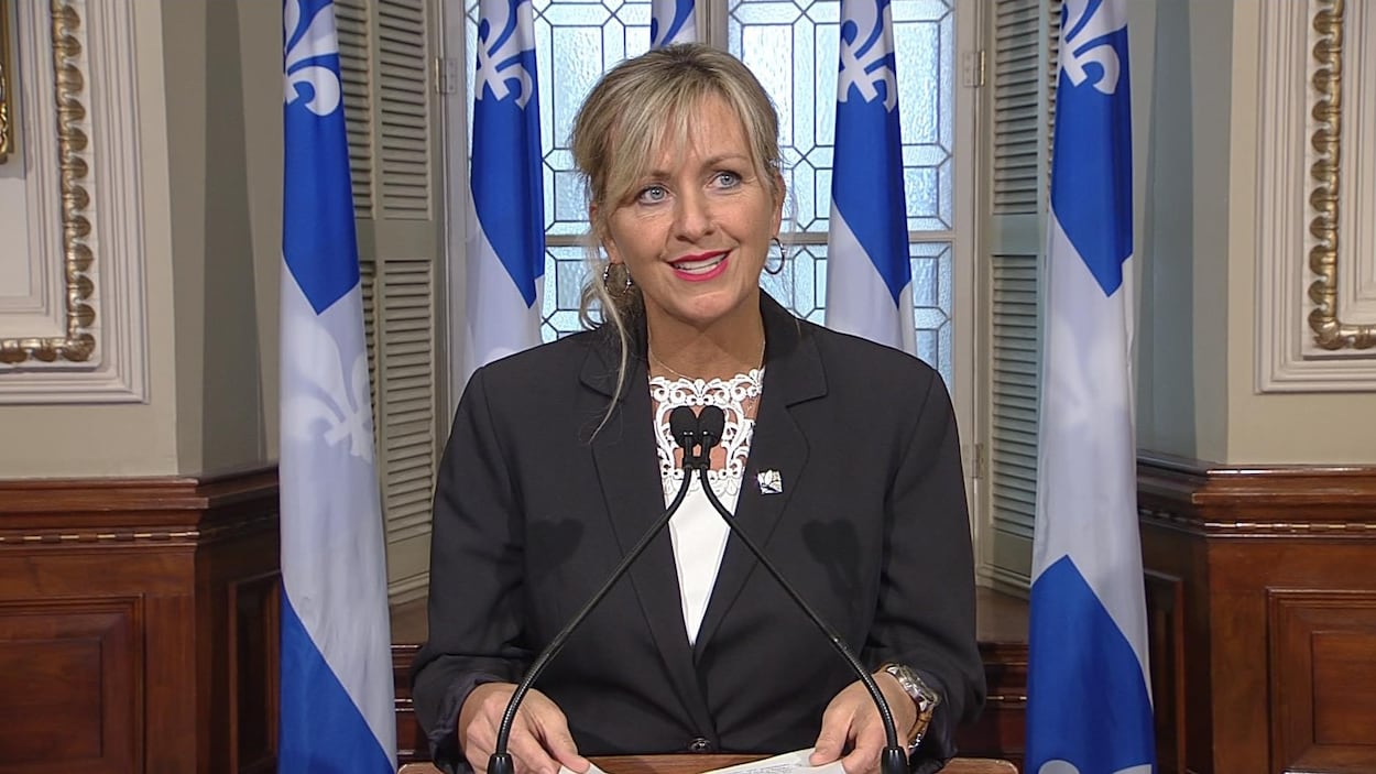 Une femme aux yeux bleus et aux cheveux blonds, dans le salon bleu du Parlement, à Québec