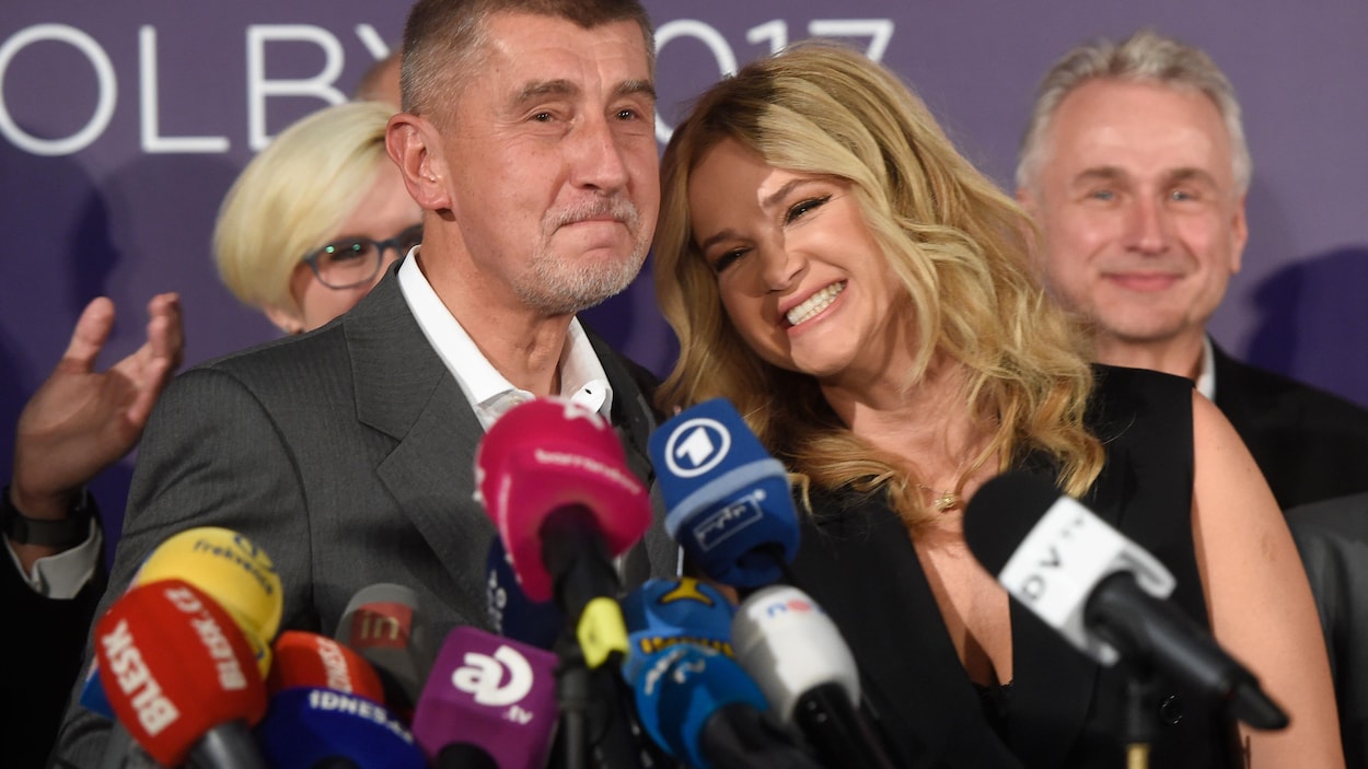 Le milliardaire tchèque Andrej Babis et sa femme Monika se tiennent debout devant plusieurs micros de journalistes.