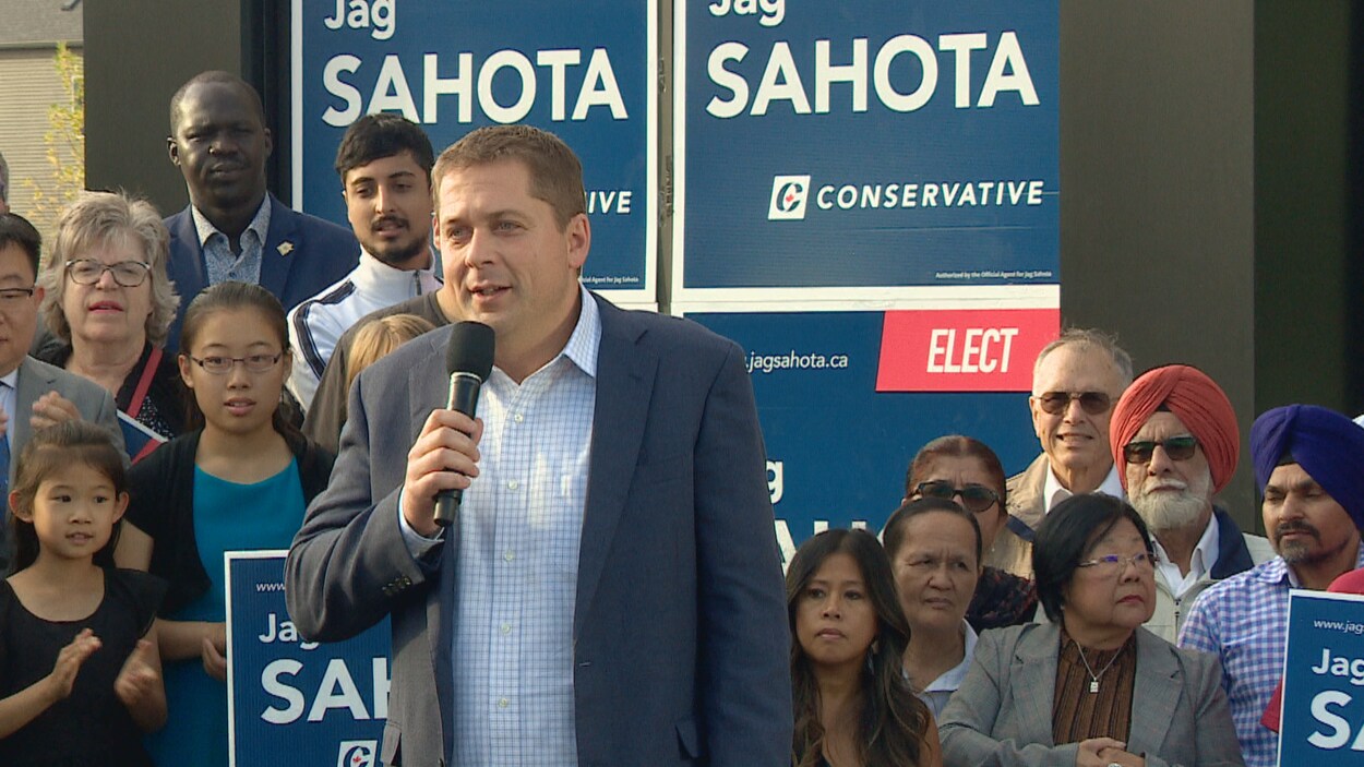 Andrew Scheer au micro devant la foule.