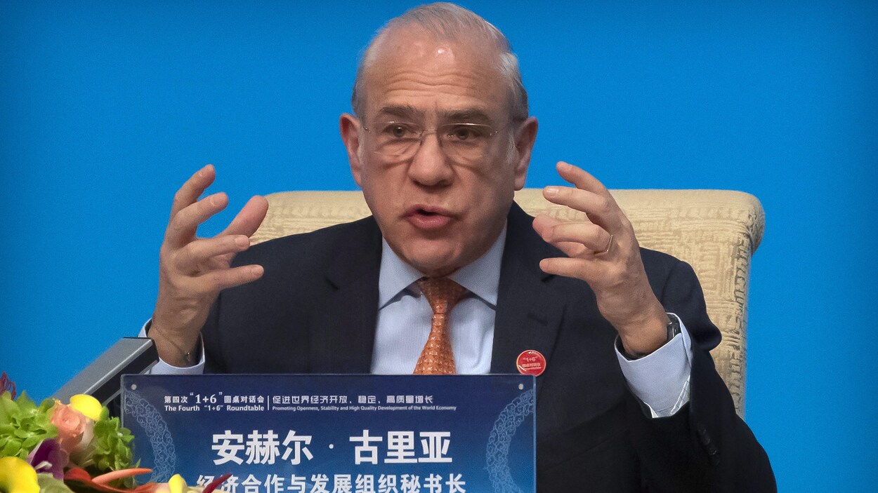 Angel Gurria parle assis à une table.