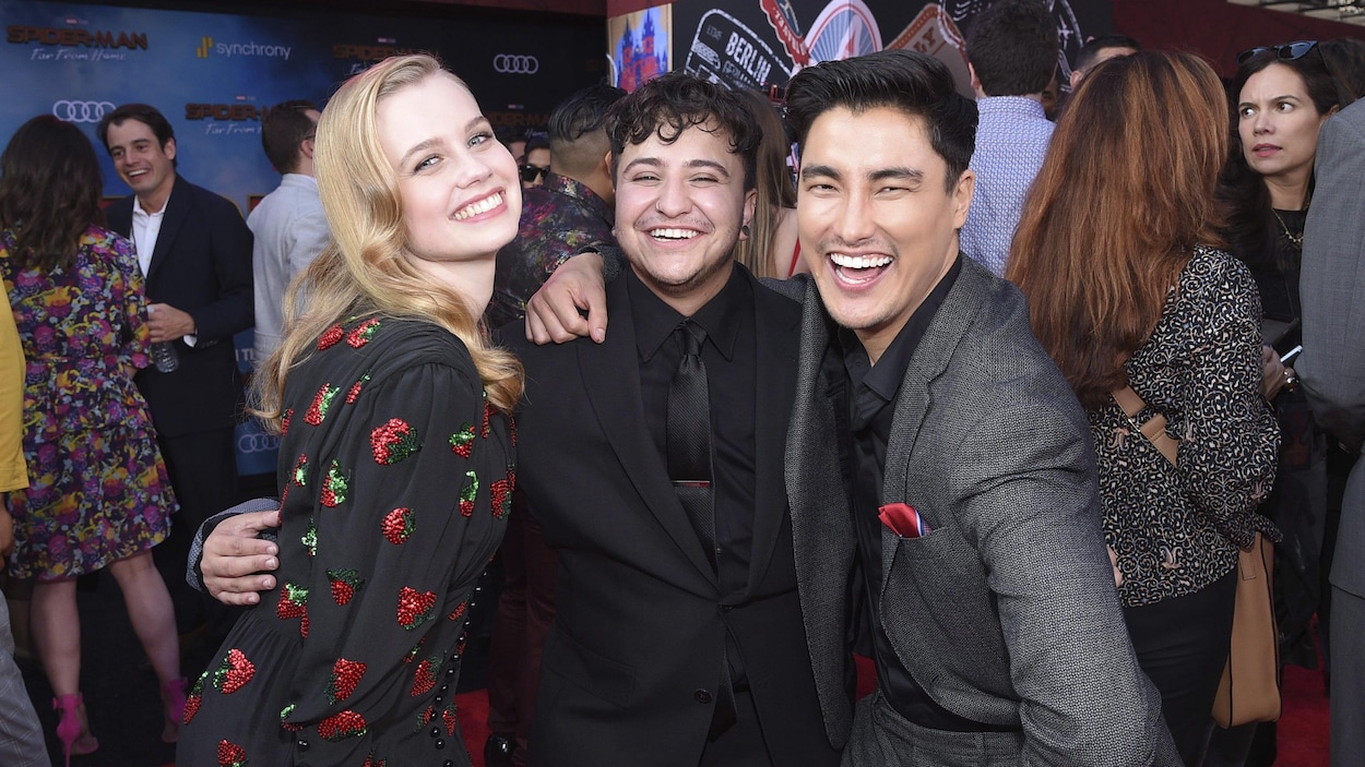 Les trois acteurs sourient pour la photo.