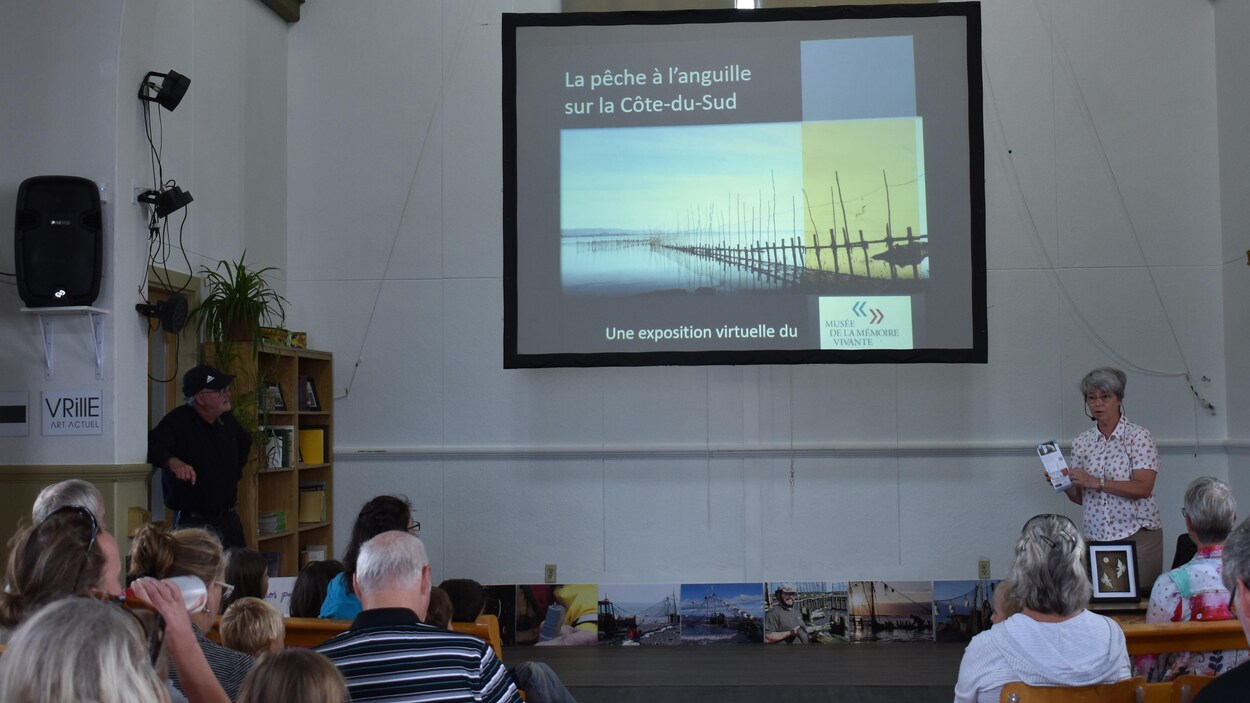 La conférencière s'adresse à une foule attentive.