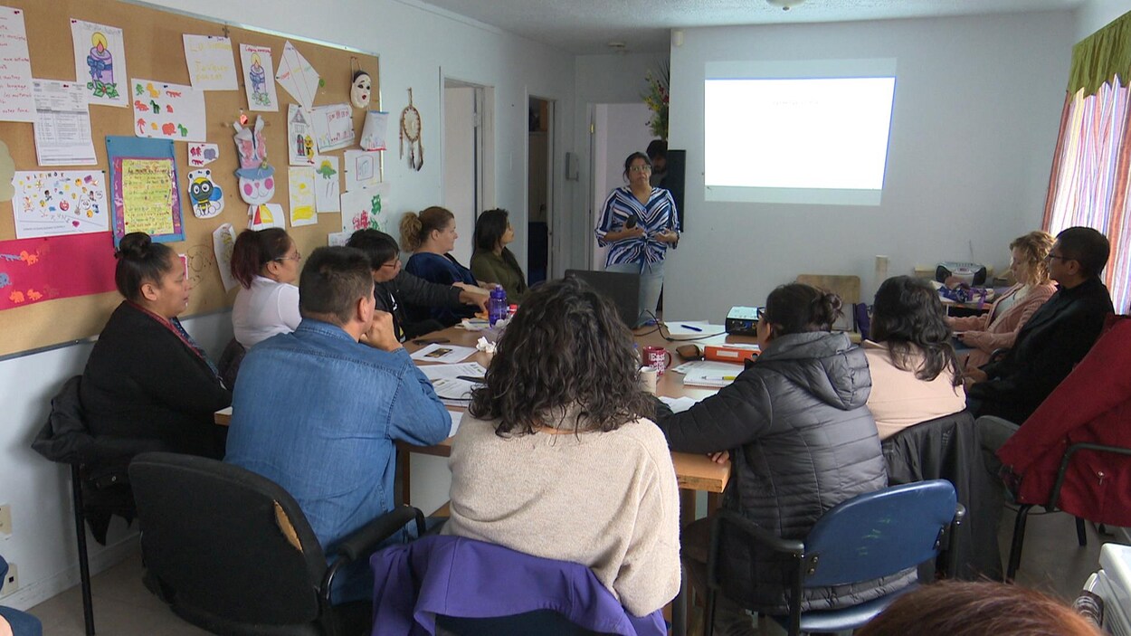 Une dame s'adresse à un groupe de personnes. Une dame s'adresse à un groupe de personnes.