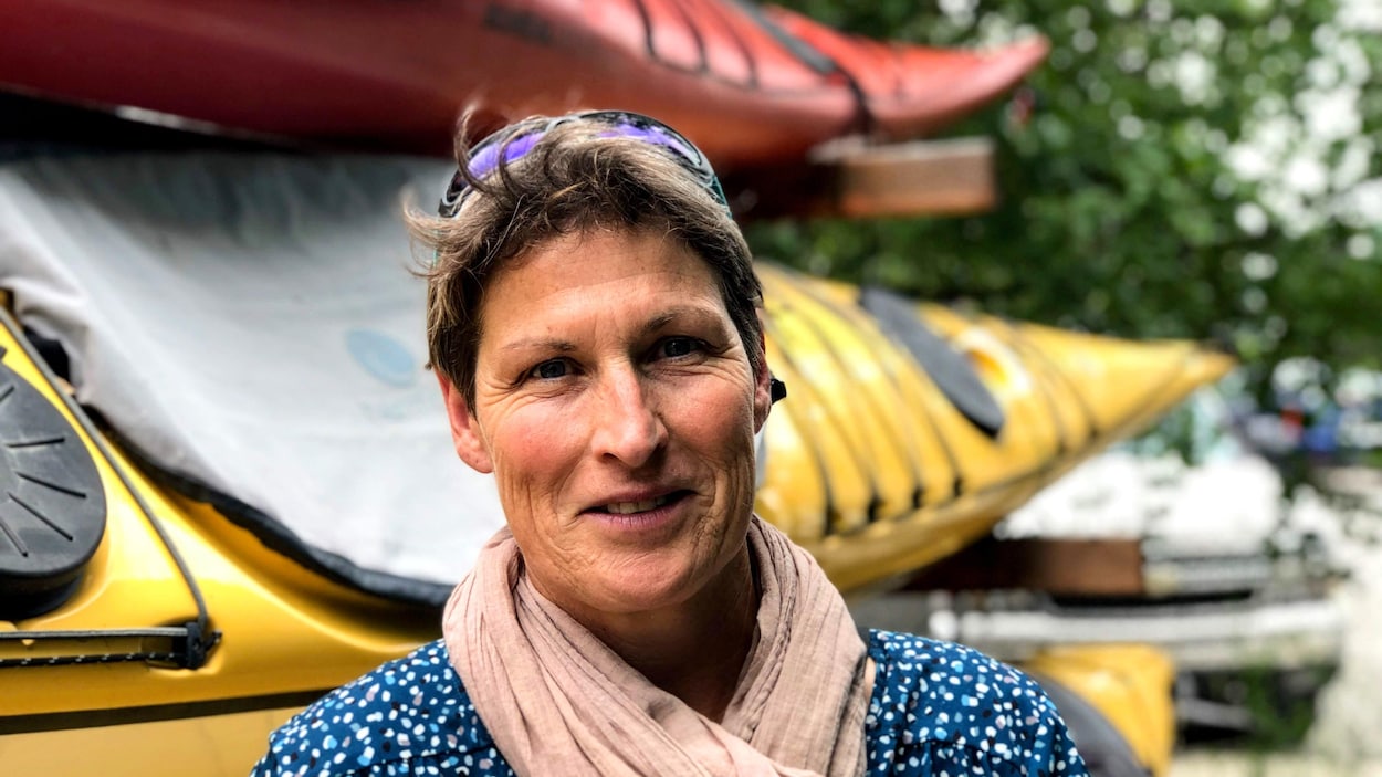 Une femme devant des kayaks.
