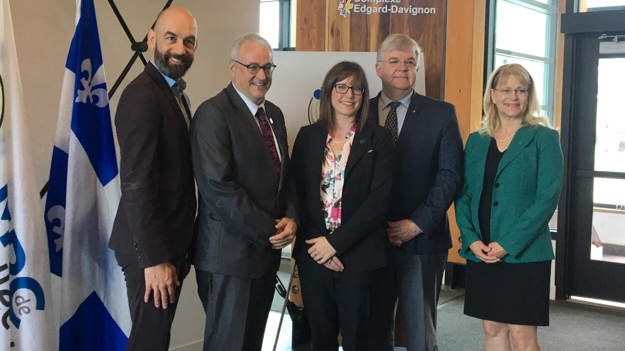 Trois homme et deux femmes posent pour la caméra après une annonce du gouvernement du Québec.