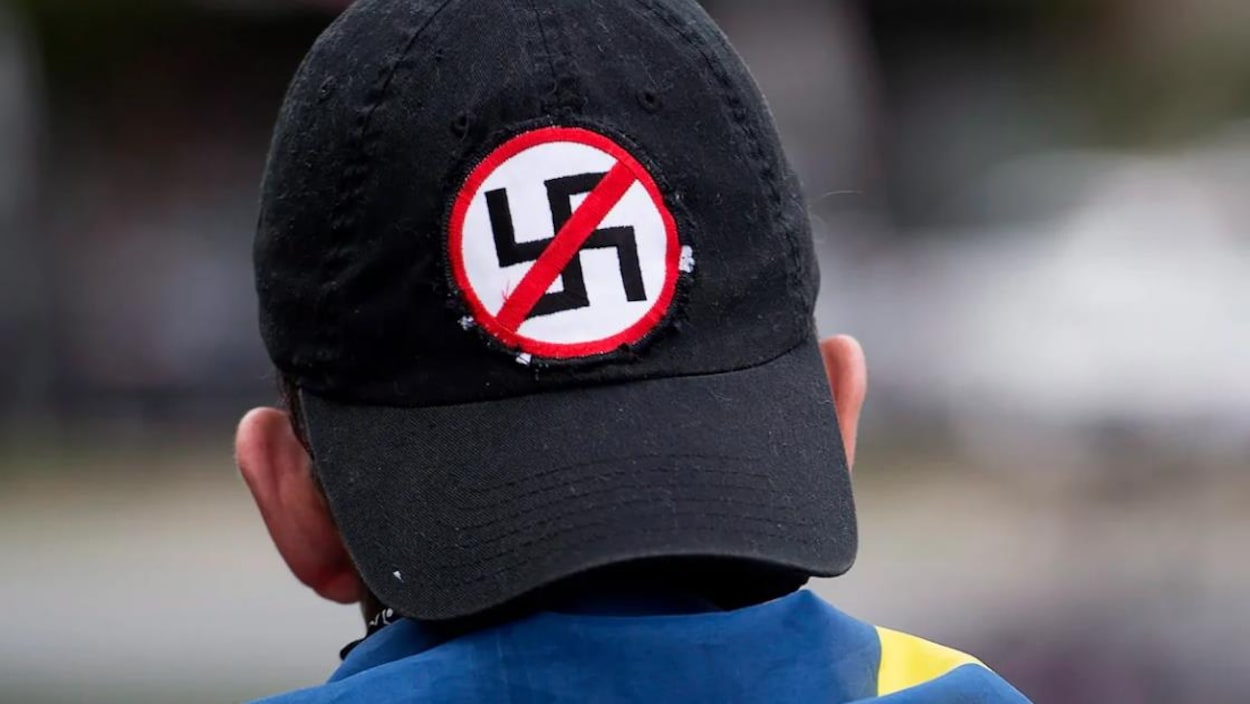 Gros plan sur le derrière d'une casquette noire avec le symbole anti-nazi.