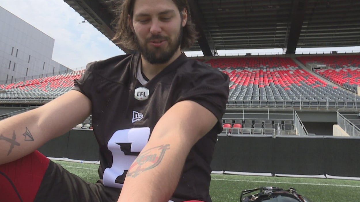 Un joueur de football assis sur le terrain dans un stade