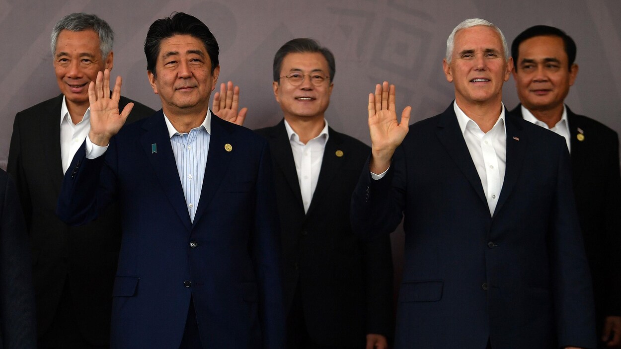 Le président chinois Xi Jinping et le vice-président américain Mike Pence participent côte à côte à une photo officielle.