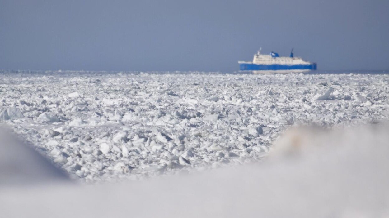 De la glace en avant-plan et le bateau à l'arrière.