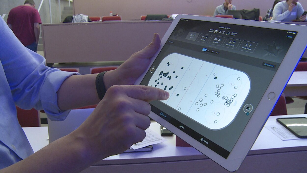 Un homme pointe quelque chose sur une tablette électronique.