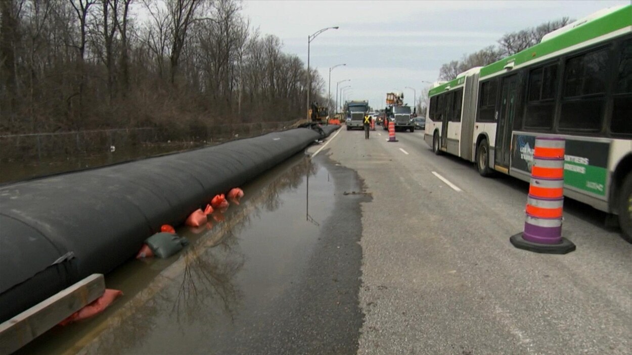 Un long boyau rempli d'eau longe le bord de l'autoroute.