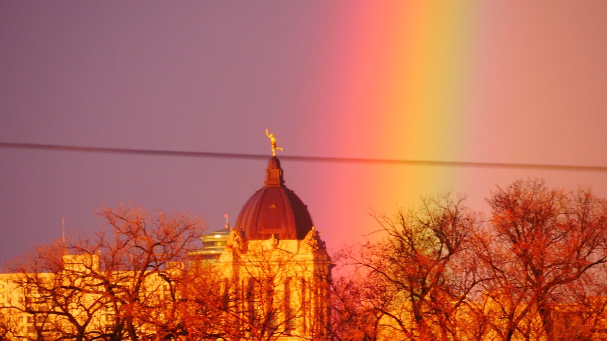 Un arc-en-ciel côtoie le haut du palais législatif que surplombe la statue du Golden Boy.