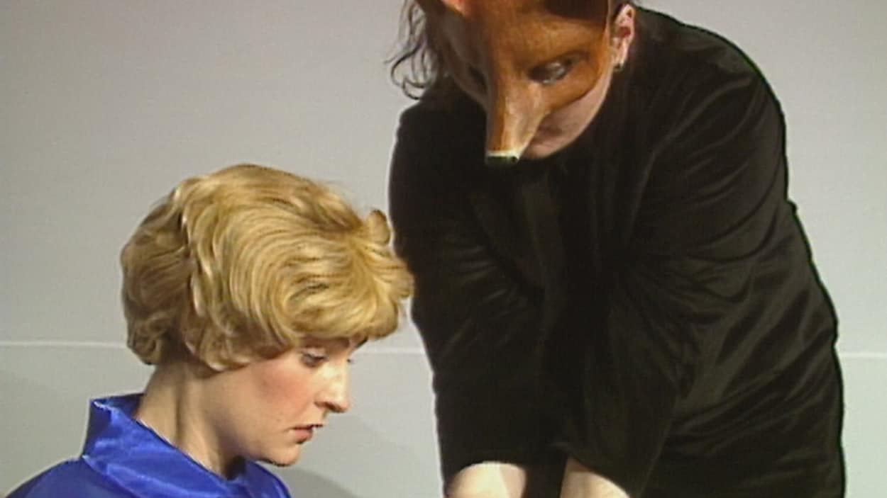Le visage de côté d'une comédienne qui interprète le Petit Prince dans la pièce de 1996 de La Troupe du jour. Elle regarde les mains d'une fille habillée en noir avec un masque d'animal. Le visage de côté d'une comédienne qui interprète le Petit Prince dans la pièce de 1996 de La Troupe du jour. Elle regarde les mains d'une fille habillée en noir avec un masque d'animal.