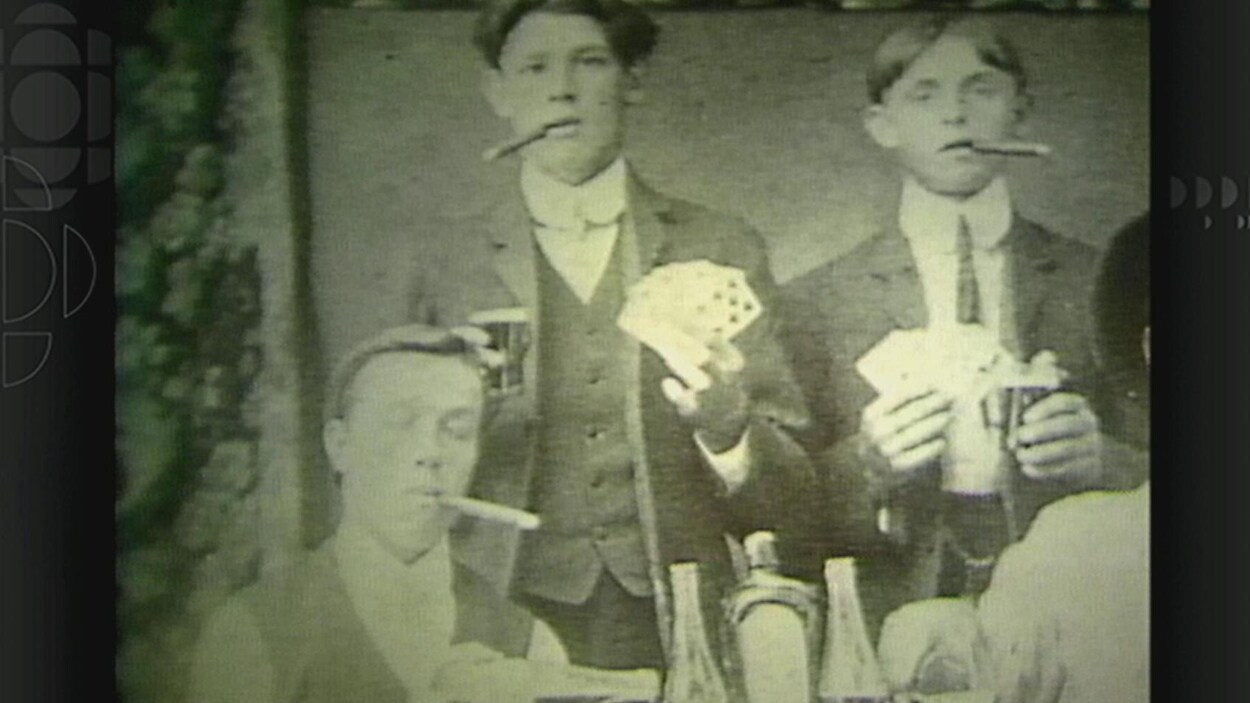 Des jeunes qui fument des cigars et jouent aux cartes