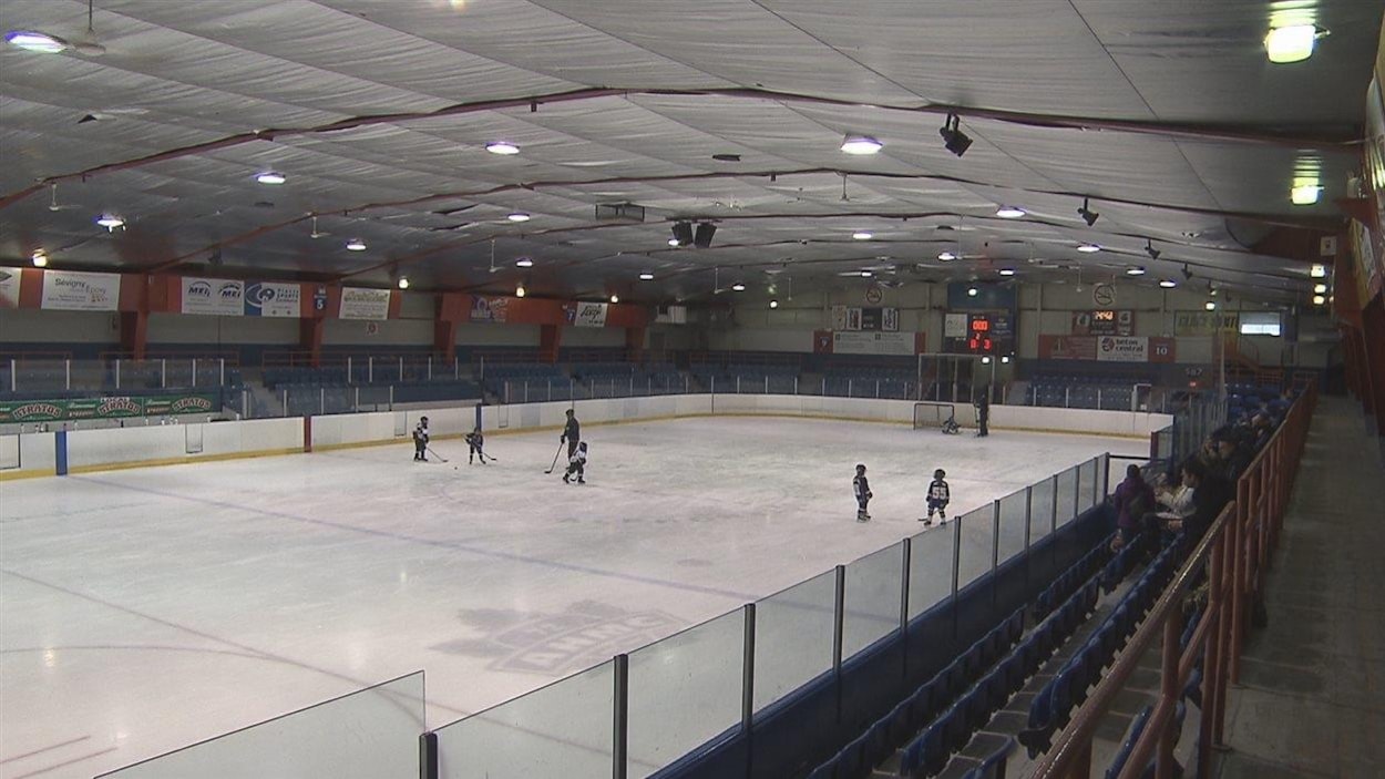 De jeunes hockeyeurs sur la glace et des gens dans les estrades.