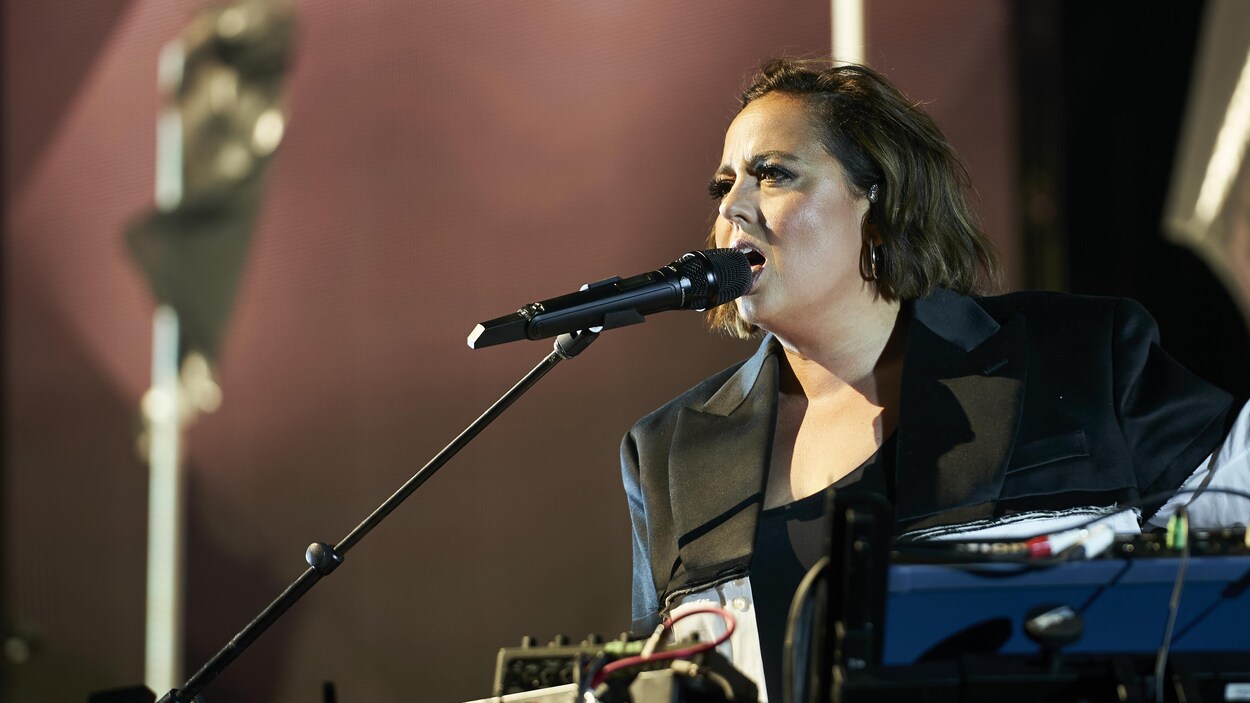 La chanteuse est sur la scène devant un micro.