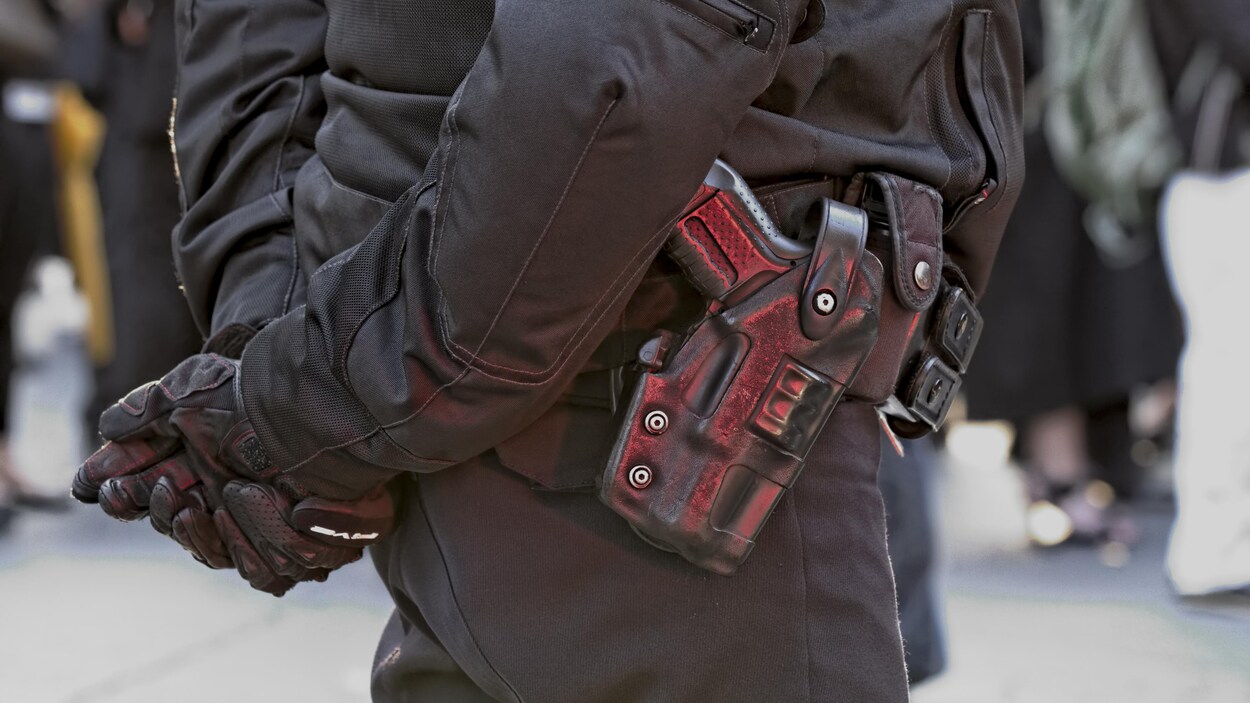 Gros plan sur l'arme de service d'un policier.