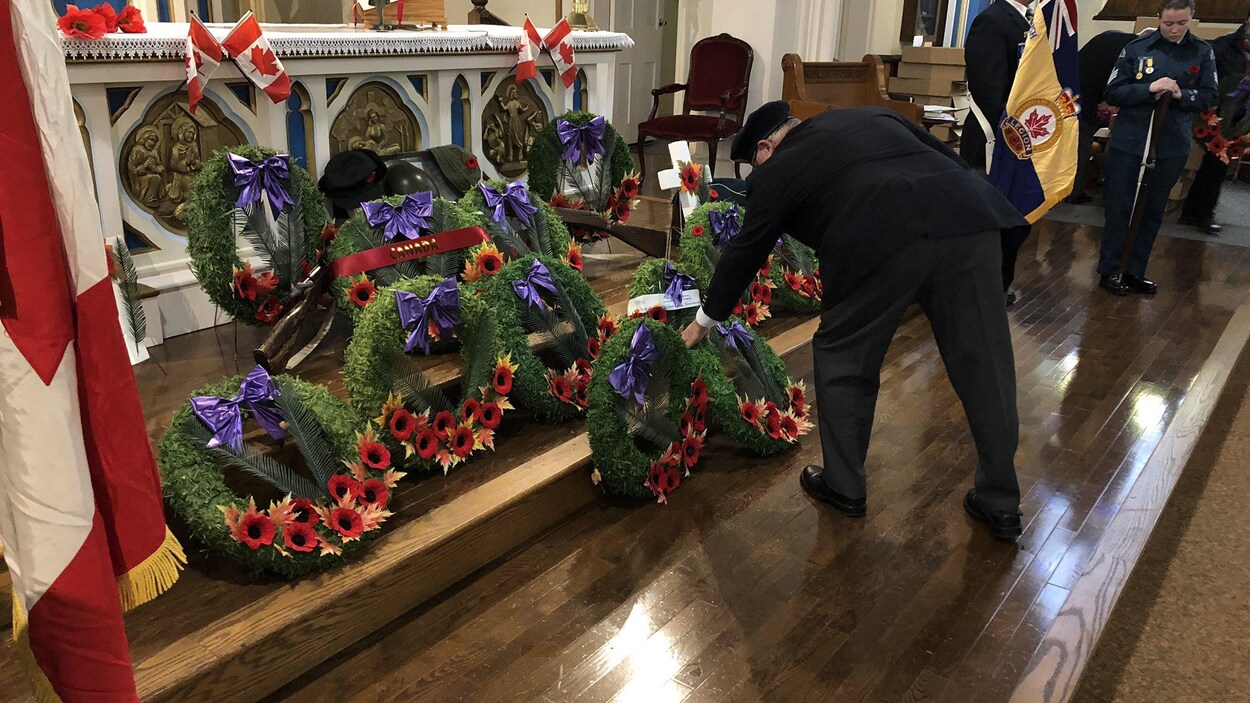 Des gens dans une église rendent hommage aux anciens combattants.