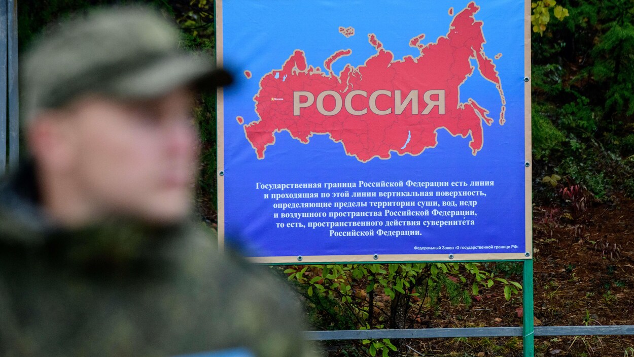 Une grande carte de la Russie derrière le soldat.
