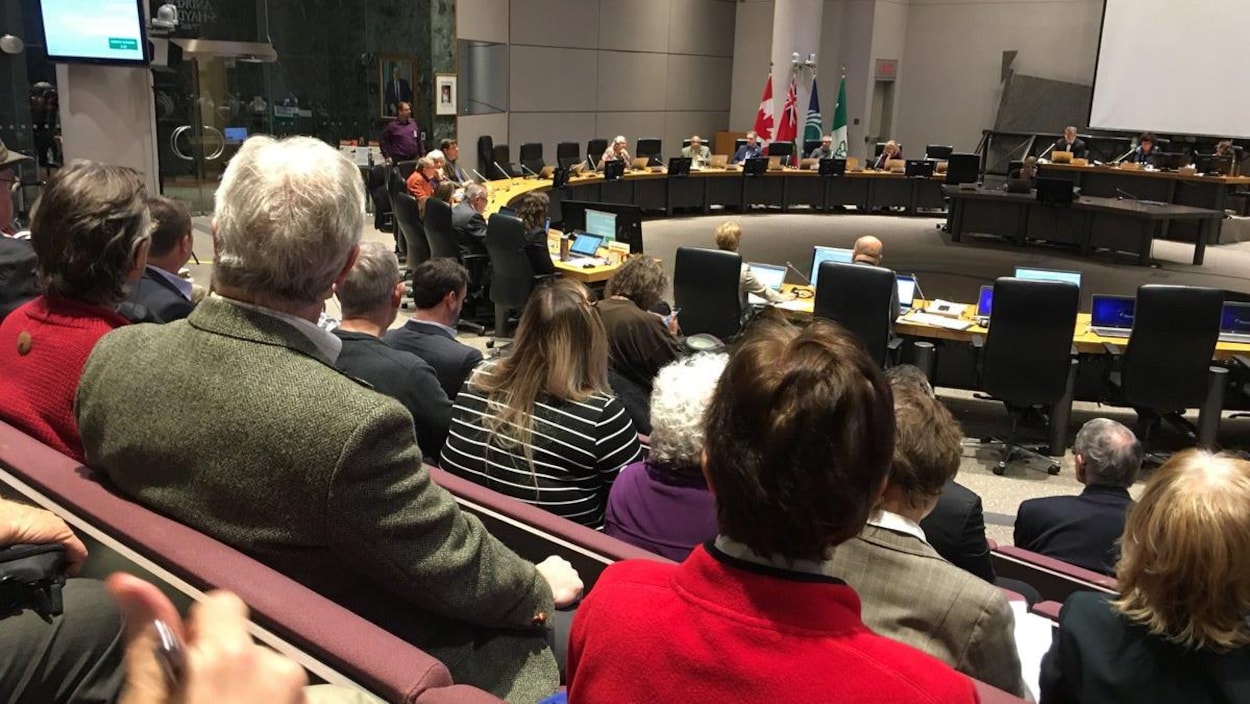 Des citoyens sont assis en rang dans les tribunes du public dans la salle du conseil Des citoyens sont assis en rang dans les tribunes du public dans la salle du conseil