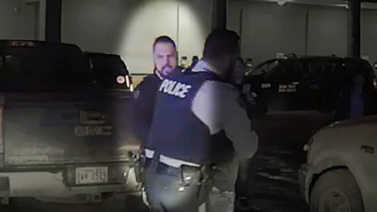 Un policier derrière un collègue lors d'une arrestation.