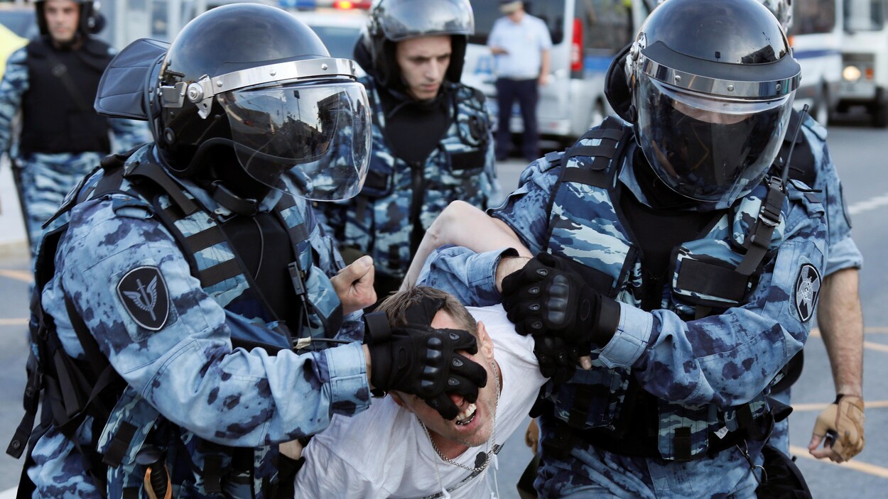 Des policiers arrêtent un manifestant.