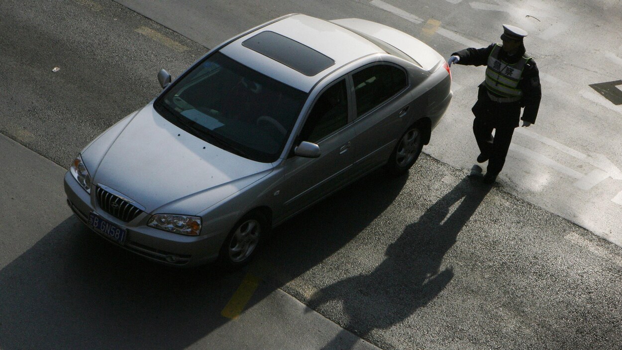 Un policier arrête un automobiliste.