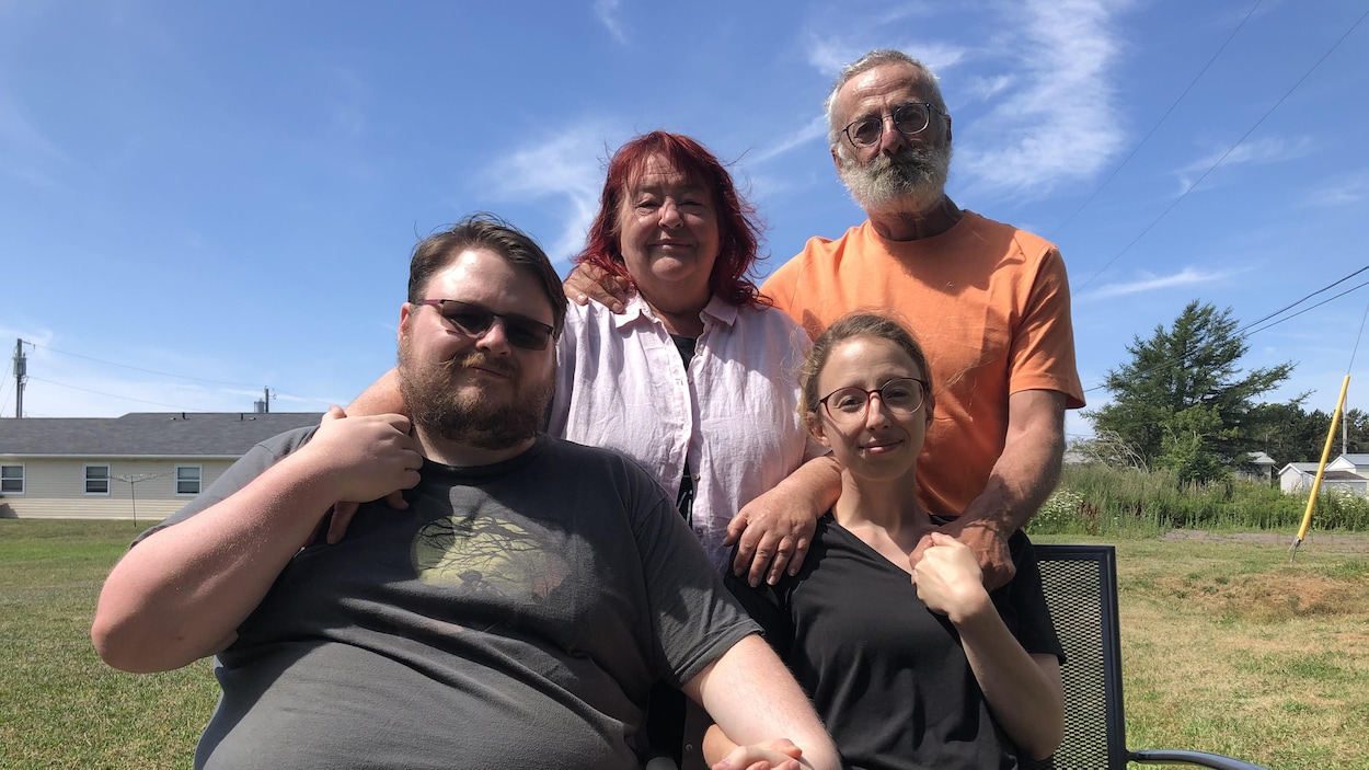 La famille est à l'extérieur sur une pelouse.